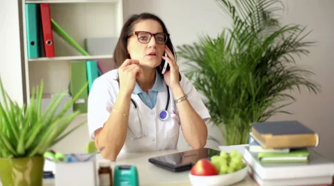 Doctor talking on cellphone and making an appointment Видео 61553885