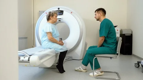 Doctor talking to elderly female patient. MRI or CT scan in modern hospital. 4K 스톡 동영상 122665553