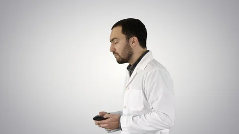 Doctor talking on mobile phone on gradient background. 스톡 동영상 114696987