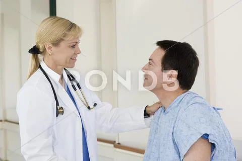 Doctor talking to patient in hospital corridor Stock Photos