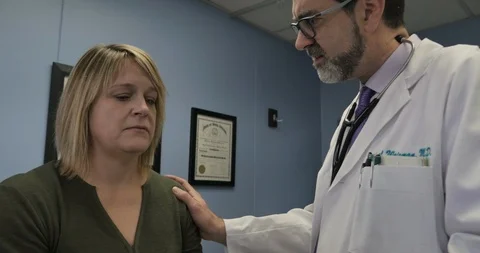 Doctor talking to a patient while she reacts in a serious sad manner Video stock 102348810