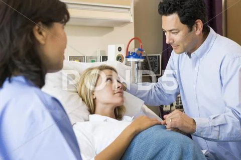 Doctor Talking To Pregnant Woman And Her Husband Stock-Fotos