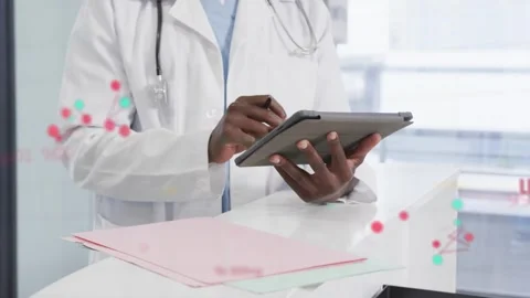 Doctor tapping tablet at desk using stylus starting SpO2 node overlays across 스톡 동영상 333774567