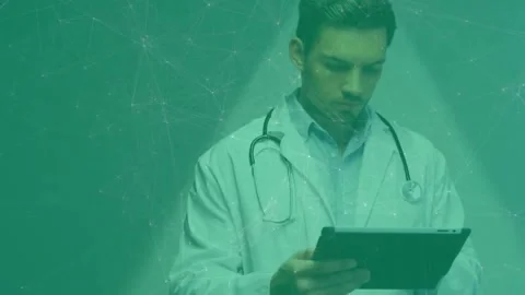 Doctor tapping tablet while checking patient data, camera zooming and teal mesh Stock Footage 330444345