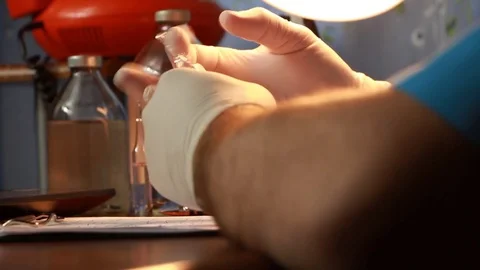 The doctor taps a finger on the vial solution for injection Stock Footage 85174388