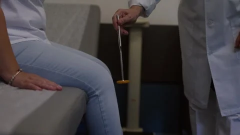Doctor Testing Patient Knee Reflex With Medical Hammer In Clinic Stock Footage 340875879