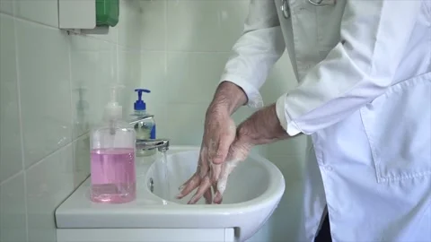 The doctor thoroughly washes his hands Stock Footage