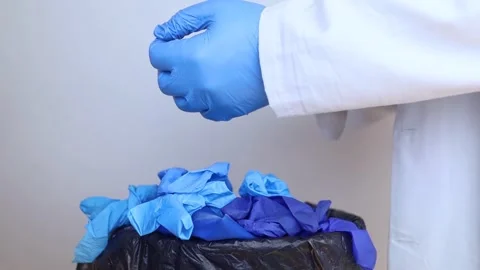Doctor throws disposable gloves into trash bin. Medical waste disposal and treat Stock Footage 286208845