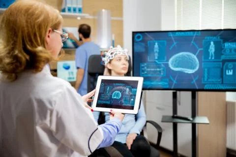 Doctor tracking the evolution of the patient's brain on the tablet 스톡 사진