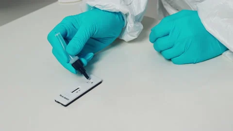 Doctor transfer drops of liquid sample to test cassette of Coronavirus test Stock Footage 163711061