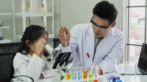 Doctor try having students use through microscope in laboratory at school. Li Video stock 138315050