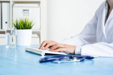 Doctor typing at computer keyboard Stock Photos