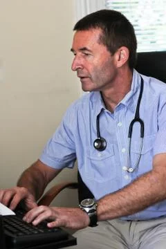 Doctor typing on a computer Stock Photos