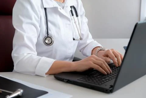 Doctor typing on the computer. Reception at the doctor's office. Stock Photos