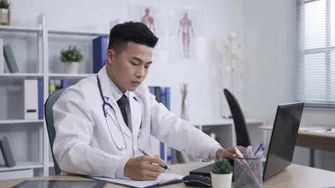 Doctor is typing looking up information Video stock 156609736