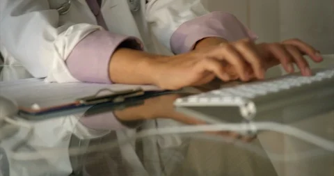 Doctor typing notes at desk. Vidéo 93865055