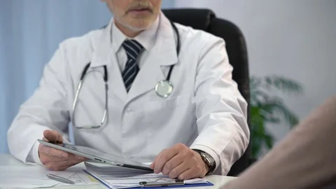 Doctor typing patient's data on tablet, keeping medical records, consultation Video stock 71639763