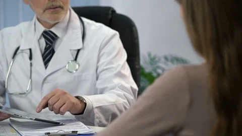 Doctor typing patient's data on tablet, keeping medical records, consultation Video stock 71640557