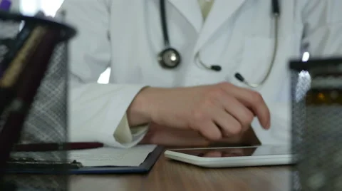 Doctor typing on tablet  Stock Footage 64066030