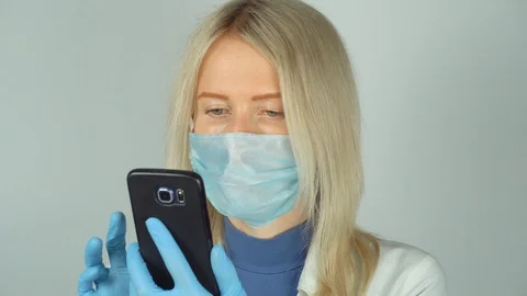 Doctor in uniform, communicates through application in smartphone. Stock Footage 128959419