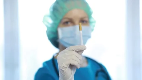 The doctor in the uniform throws a cigarette. Stock Footage 82854260