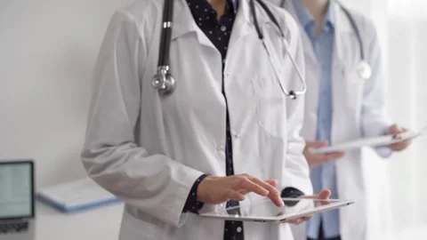 Doctor use a tablet computer for making medication notes while another physician 動画素材 252397061