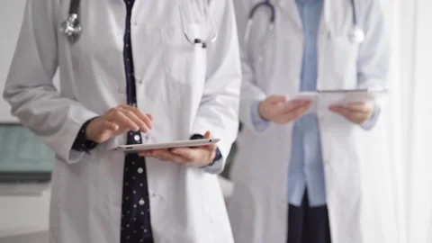 Doctor use a tablet computer for making medication notes while another physician 動画素材 254155079