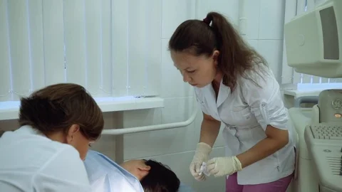 The doctor uses a clamp to pull out the contraceptive subcutaneous implant. A Stock Footage 83762387