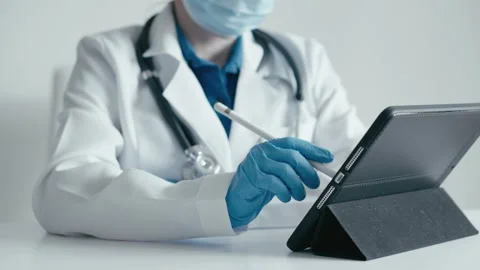 The doctor uses an electronic tablet to develop an individual treatment plan and Stock Footage 247765615