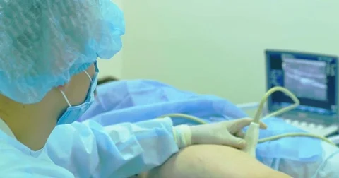 A doctor uses a modern sonogram to view vein in sclerotherapy procedure. An Stock Footage 82940178
