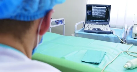 A doctor uses a modern sonogram to view vein in sclerotherapy procedure. An Video stock 102172366