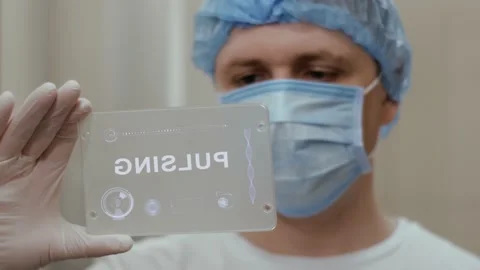 Doctor uses tablet with text Pulsing Stock-Footage 130861780