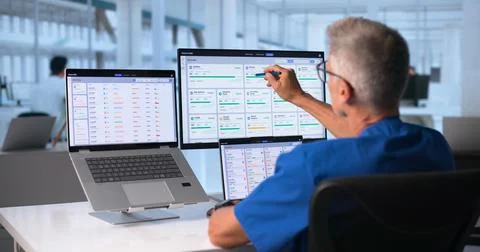 Doctor Uses Touchscreen Computer To Review Patient Health Data Efficiently. Stock Photos