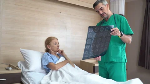 Doctor using brain X-ray film explain the symptoms to the senior patient afte Stock Footage 159705430