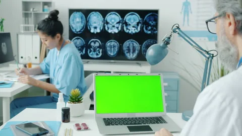 Doctor using chroma key green screen laptop while nurse writing medical records Stock Footage 174078722