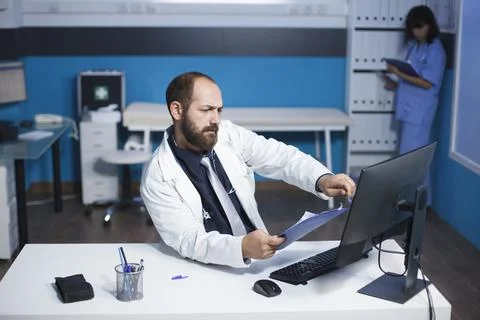 Doctor using a clipboard and computer Stock Photos