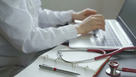 Doctor using computer, focus on stethoscope on foreground Video stock 103836076