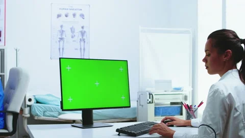Doctor using computer with green screen display Stock Footage 135651158