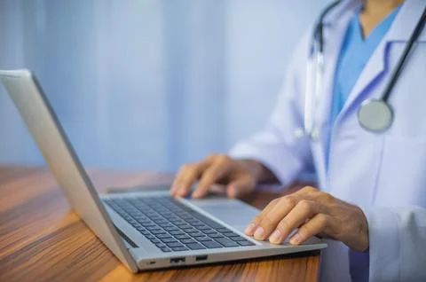 Doctor using computer typing on keyboard. Doctor computer Stock Photos