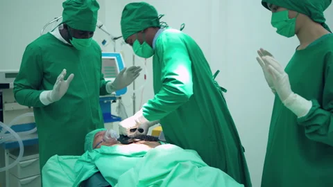 Doctor using defibrillator electrods in the operating room Video stock 195003635
