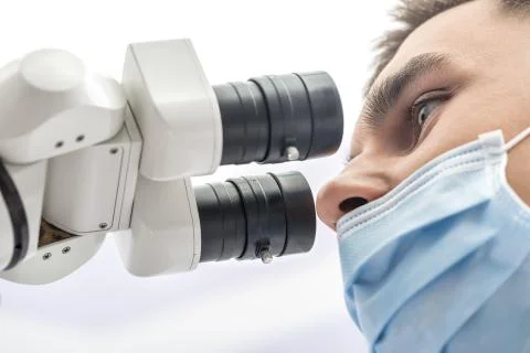 Doctor using a dental microscope Stock Photos