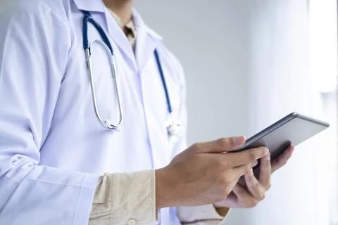 Doctor using a digital tablet computer at work. Stock Photos
