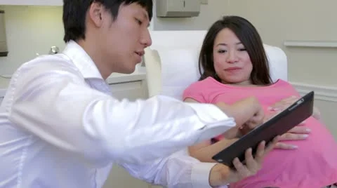 Doctor Using Digital Tablet In Examination Of Pregnant Woman Stock Footage 30819828