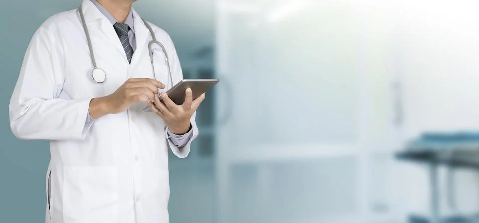 Doctor using a digital tablet working on hospital Stock Photos
