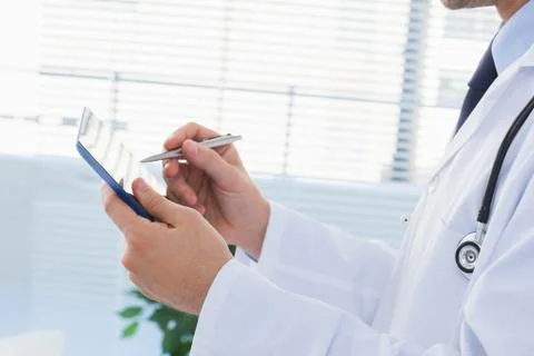 Doctor using his tablet pc Stock Photos