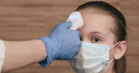 Doctor using infrared thermometer checking body temperature of a girl Stock Footage 133706050