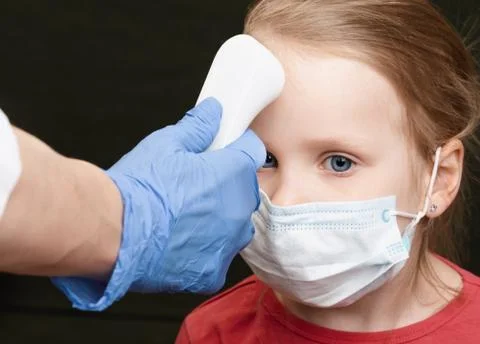 Doctor using infrared thermometer checking body temperature of little girl we Stock Photos