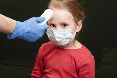 Doctor using infrared thermometer checking body temperature of little girl we 스톡 사진