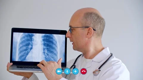 Doctor using laptop with x-ray image of lungs during video chat Stock Footage 131582886