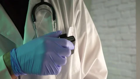Doctor Using a Pager Beeper To Receive Important Information Stock Footage 139010906